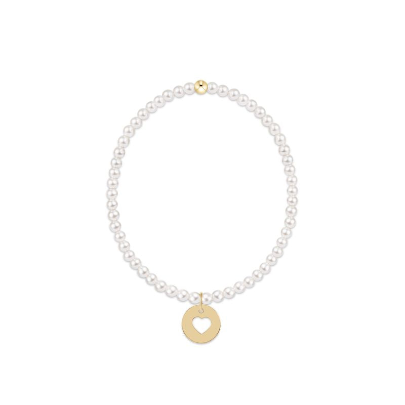 Pearl bracelet with a gold heart charm on a white background
